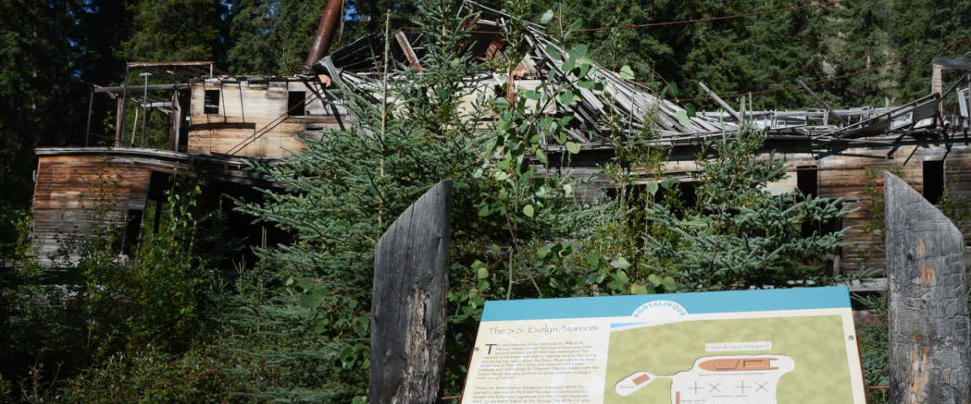 The interpretive sign sits in front of the wreck of the S.S. Evelyn on Shipyard Island.